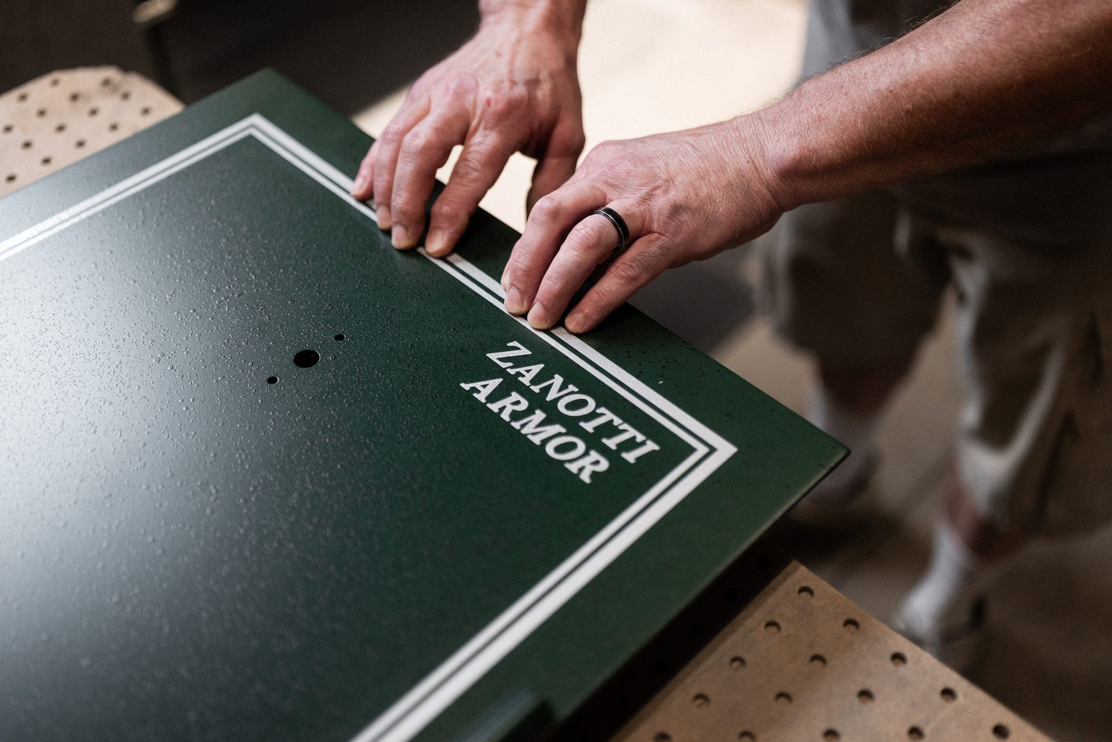 Hands trimming a steel panel